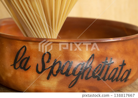 Close up of traditional terracotta bowl with dry spaghetti bundle Close up of traditional terracotta bowl with dry spaghetti bundle 138817667