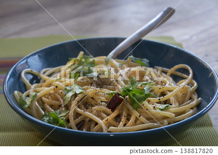 Spaghetti aglio olio e peperoncino with fresh parsley in blue bowl 138817820