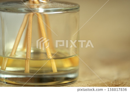 Glass reed diffuser with essential oil on wooden surface for wellness Glass reed diffuser with essential oil on wooden surface for wellness 138817836