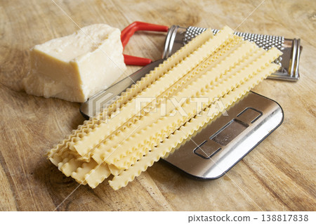 Dry lasagna pasta on digital kitchen scale with parmesan cheese 138817838