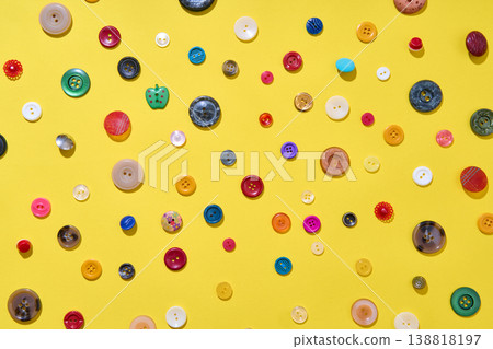 Colorful sewing buttons on bright yellow background Colorful sewing buttons on bright yellow background 138818197