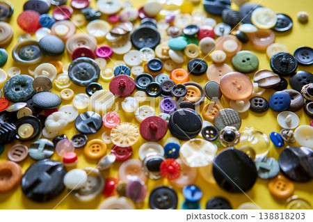 Colorful sewing buttons on bright yellow background Colorful sewing buttons on bright yellow background 138818203