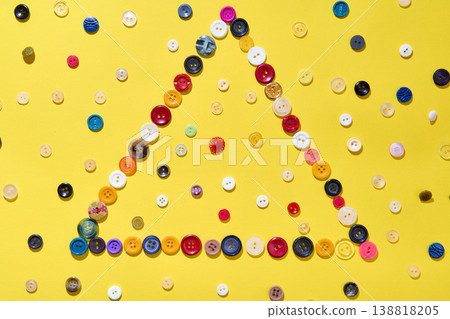 Triangle frame made of colorful buttons 138818205