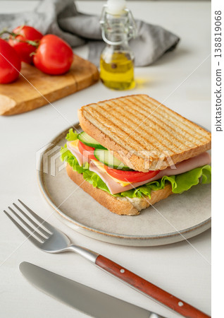 Club sandwich with ham, cheese, tomatoes, lettuce, cucumber on a plate on a white background Club sandwich with ham, cheese, tomatoes, lettuce, cucumber on a plate on a white background 138819068