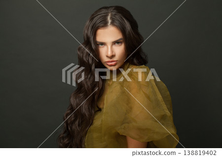 Indoor portrait of woman hair. Beautiful model with long curly hairstyle posing Indoor portrait of woman hair. Beautiful model with long curly hairstyle posing 138819402