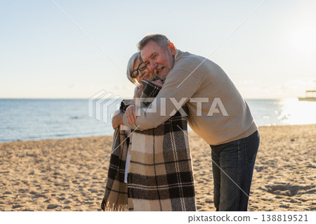 Senior mature couple hugging enjoying outdoor recreation walking on beach. Old husband wife embracing with tenderness love enjoying sweet bonding. Grandmother grandfather together. Family moment love Senior mature couple hugging enjoying outdoor recreation walking on beach. Old husband wife embracing with tenderness love enjoying sweet bonding. Grandmother grandfather together. Family moment love 138819521