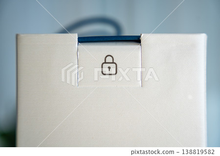 Close up of secure packaging with lock icon on box seal. Safe delivery and product protection concept with tamper evident packaging. Close up of secure packaging with lock icon on box seal. Safe delivery and product protection concept with tamper evident packaging. 138819582