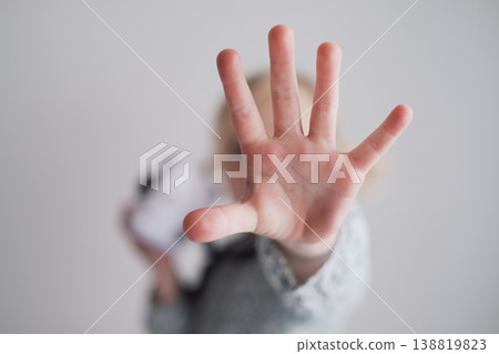 Serious 4 year old girl showing stop gesture with her outstretched palm toward the camera Serious 4 year old girl showing stop gesture with her outstretched palm toward the camera 138819823