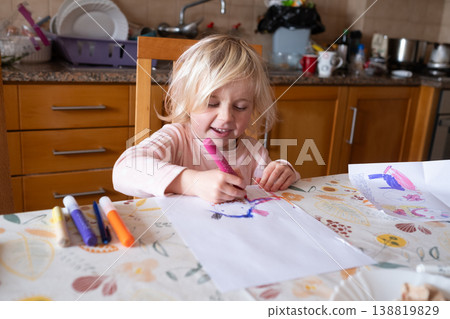 Little Artist: Focused 4 year old girl drawing with colorful felt-tip markers at the kitchen table 138819829