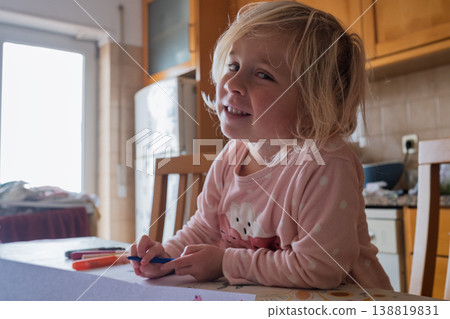 Little Artist: Focused 4 year old girl drawing with colorful felt-tip markers at the kitchen table 138819831