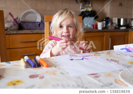 Little Artist: Focused 4 year old girl drawing with colorful felt-tip markers at the kitchen table 138819839