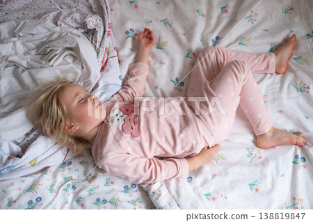 Peaceful 4 year old girl sleeping in cozy pajamas in a sunlit bedroom Peaceful 4 year old girl sleeping in cozy pajamas in a sunlit bedroom 138819847