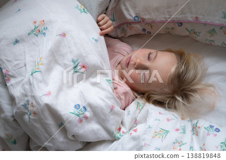 Peaceful 4 year old girl sleeping in cozy pajamas in a sunlit bedroom Peaceful 4 year old girl sleeping in cozy pajamas in a sunlit bedroom 138819848