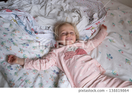 Peaceful 4 year old girl sleeping in cozy pajamas in a sunlit bedroom Peaceful 4 year old girl sleeping in cozy pajamas in a sunlit bedroom 138819864