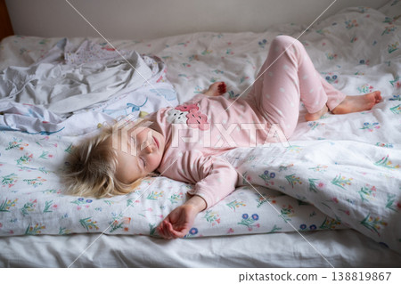 Peaceful 4 year old girl sleeping in cozy pajamas in a sunlit bedroom Peaceful 4 year old girl sleeping in cozy pajamas in a sunlit bedroom 138819867