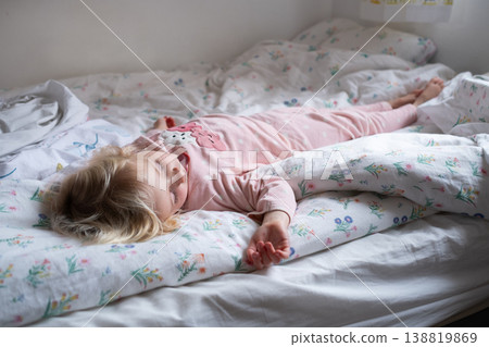 Peaceful 4 year old girl sleeping in cozy pajamas in a sunlit bedroom Peaceful 4 year old girl sleeping in cozy pajamas in a sunlit bedroom 138819869