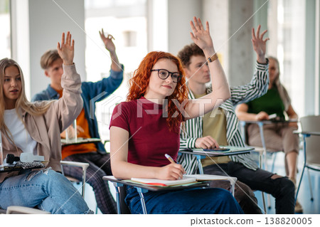 Group of college students attending lecture in university hall. Group of college students attending lecture in university hall. 138820005