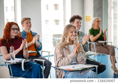 Students applauding during university lecture in modern classroom. 138820007