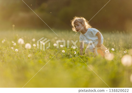 Cute girl playing on meadow, in spring nature. 138820022