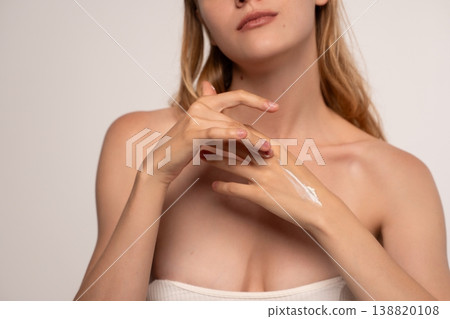 Woman applying skincare moisturizer to her hands, taking care of her skin. Concept of beauty, hydration, and wellness Woman applying skincare moisturizer to her hands, taking care of her skin. Concept of beauty, hydration, and wellness 138820108