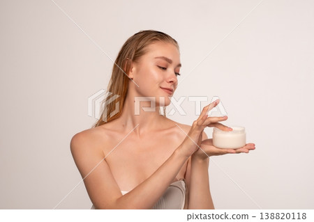 Young woman applying skincare cream, enjoying beauty routine for healthy glowing skin and wellness Young woman applying skincare cream, enjoying beauty routine for healthy glowing skin and wellness 138820118