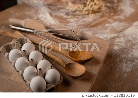 Cooking ingredients and baking tools with flour and dough on a wooden surface preparing a homemade recipe Cooking ingredients and baking tools with flour and dough on a wooden surface preparing a homemade recipe 138820119