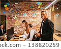 People collaborating in an office with colorful graphics on the wall during a planning session in the afternoon 138820259