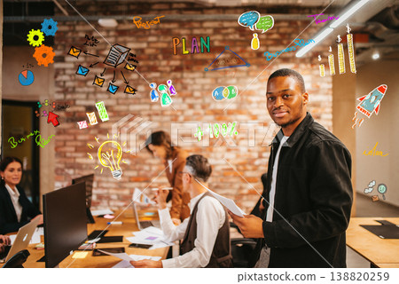 People collaborating in an office with colorful graphics on the wall during a planning session in the afternoon 138820259