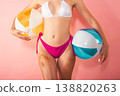 Woman holding beach balls in a bright setting during summer 138820263