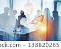 Business meeting with team member writing on glass board in city office during daylight hours 138820265
