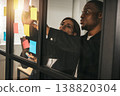 Team members work together on sticky notes in an office setting during afternoon hours to brainstorm ideas and organize tasks 138820304