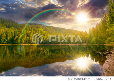 sunset over landscape by the lake. coniferous forest near the lake and the forest mountain. awesome summer view of carpathian mountain reflection on synevr lake water surface under the rainbow sunset over landscape by the lake. coniferous forest near the lake and the forest mountain. awesome summer view of carpathian mountain reflection on synevr lake water surface under the rainbow 138820723
