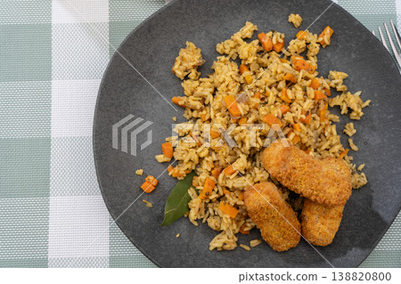 Exquisite saffron rice dish with spiced breaded and fried fish sticks Exquisite saffron rice dish with spiced breaded and fried fish sticks 138820800