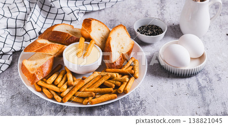 Egg sauce in a bowl, breadsticks and bread on a plate on the table web banner Egg sauce in a bowl, breadsticks and bread on a plate on the table web banner 138821045