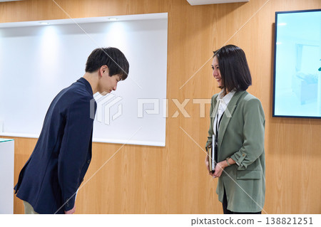 辦公室裡,商務人士,不論男女,互相微笑、問候、鞠躬。 辦公室裡,商務人士,不論男女,互相微笑、問候、鞠躬。 138821251