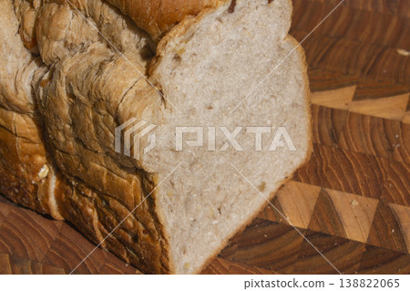 It is a slice of bread placed on a wooden cutting board. It is a slice of bread placed on a wooden cutting board. 138822065