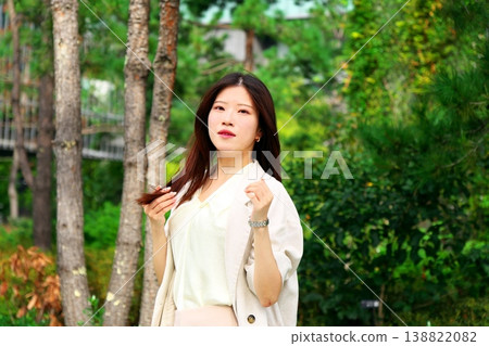 辦公室女員工在鬱鬱蔥蔥的綠植中放鬆身心，展現工作與生活的平衡以及寧靜的景色。 138822082