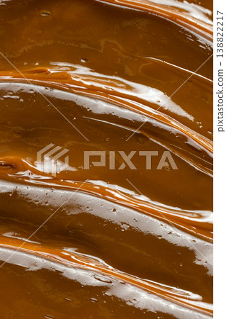 Thick caramel sauce swirl with glossy finish macro. Thick caramel sauce swirl with glossy finish macro. 138822217