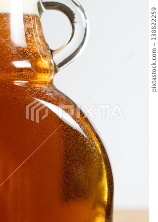 Close up of golden maple syrup in glass bottle Close up of golden maple syrup in glass bottle 138822259