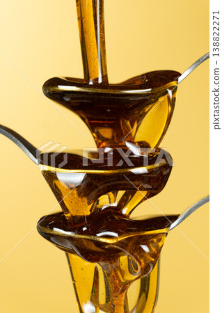 Abstract art of maple syrup flowing over spoons Abstract art of maple syrup flowing over spoons 138822271