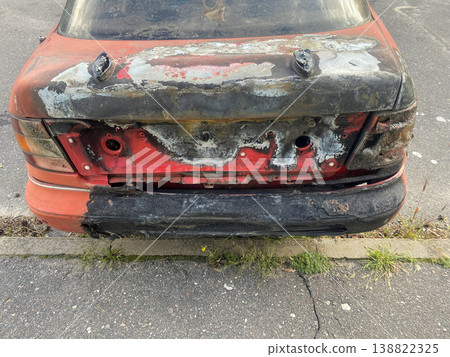 Old car with damaged rear parked on the roadside in a city on a clear day 138822325