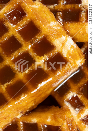 Sweet dessert background with waffles and flowing caramel syrup. Sweet dessert background with waffles and flowing caramel syrup. 138822337