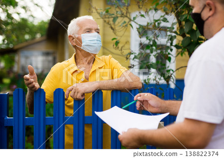 Old man in mask talking with employer of public utilities outdoors 138822374