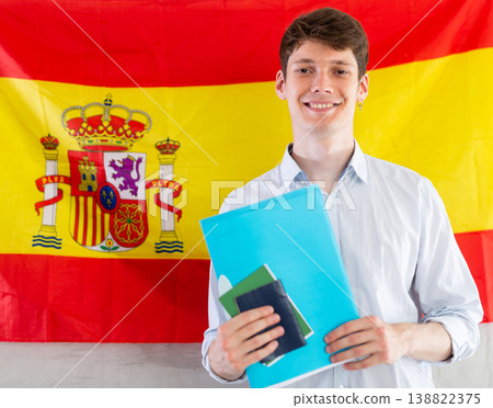 Positive student on background of flag of Spain - concept of studying abroad and immigration Positive student on background of flag of Spain - concept of studying abroad and immigration 138822375