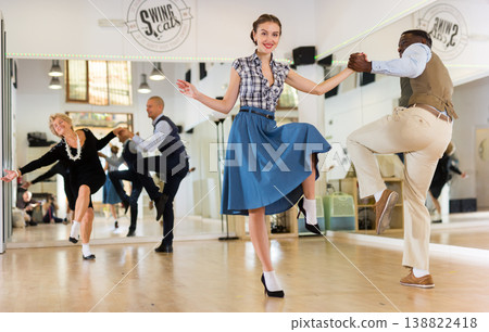 Woman with african man practising charleston dancing Woman with african man practising charleston dancing 138822418