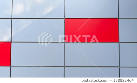 Abstract architectural background of silver metal panels with red accents reflecting soft clouds Abstract architectural background of silver metal panels with red accents reflecting soft clouds 138822464