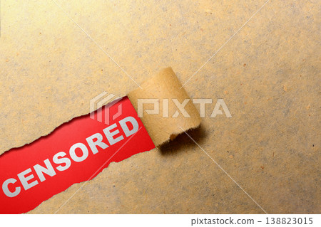 A piece of brown paper is torn open to reveal the white word CENSORED on a vibrant red background, symbolizing restricted information and media control A piece of brown paper is torn open to reveal the white word CENSORED on a vibrant red background, symbolizing restricted information and media control 138823015