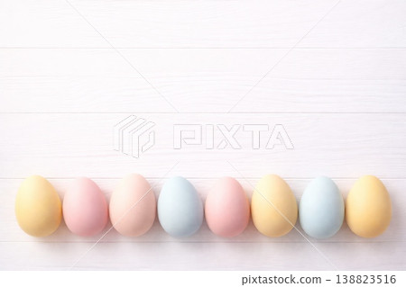 A minimal 3D illustration of pastel-colored Easter eggs arranged along a white wooden plank background. Soft matte textures, gentle shadows, clean negative space, calm spring palette, subtle depth 138823516