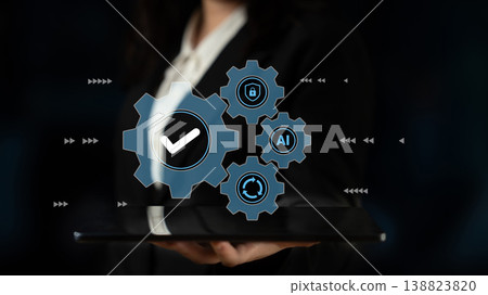 Businesswoman holding tablet with digital gears and checkmark, representing technology, AI, automation, and secure solutions in corporate setting Gantry Businesswoman holding tablet with digital gears and checkmark, representing technology, AI, automation, and secure solutions in corporate setting Gantry 138823820
