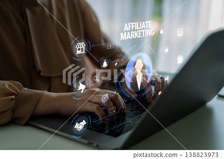 Business Professional Engaging with Online Affiliate Marketing Strategy on Laptop with Digital Icons Representing Various Aspects of Marketing Quark 138823973